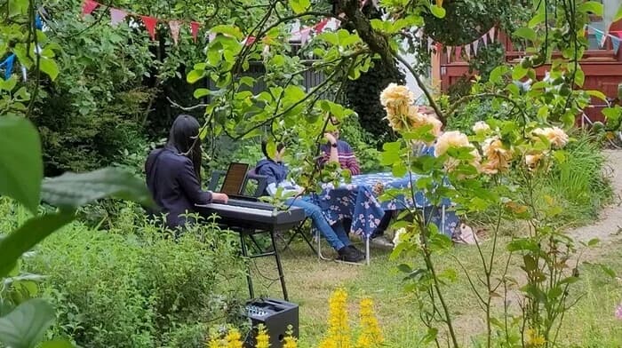 Concert de piano allongé.e à l'ombre des feuillages